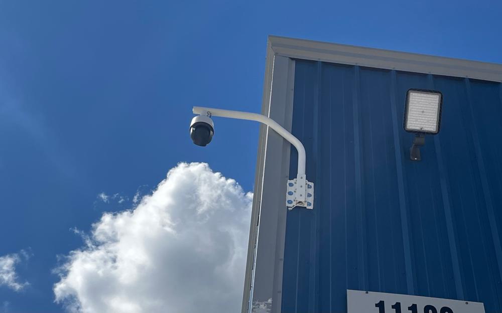 Outdoor PTZ security camera on an arm mount on a commercial building in Greater Houston